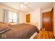 Bedroom featuring neutral walls, hardwood floors, and a queen bed, with a wooden door to the side at 506 Deerberry Dr, Noblesville, IN 46062