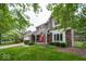 Attractive two-story home with a red door, brick accents, mature trees, and a well-manicured lawn at 506 Deerberry Dr, Noblesville, IN 46062