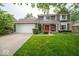 Charming two-story home with a red front door, landscaped yard, and an attached two-car garage at 506 Deerberry Dr, Noblesville, IN 46062