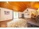 Inviting living space with a wood ceiling, providing access to the outdoors and views of the kitchen at 506 Deerberry Dr, Noblesville, IN 46062