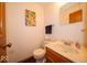 Cozy half bath with a wood vanity, tiled floors, and decorative mirror at 506 Deerberry Dr, Noblesville, IN 46062