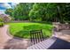 Expansive backyard with manicured lawn, stone patio, and lush green trees on a sunny day at 5073 St Charles Pl, Carmel, IN 46033