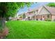 Spacious backyard with a lush green lawn, patio, play set, and a well-manicured garden at 5073 St Charles Pl, Carmel, IN 46033