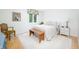 Bright, minimalist bedroom featuring a wooden bench, cream comforter, and light wood flooring at 5073 St Charles Pl, Carmel, IN 46033