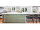 Spacious kitchen island with green cabinets, marble counters, and bar stool seating at 5073 St Charles Pl, Carmel, IN 46033
