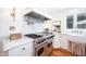 Gourmet kitchen with stainless steel range, marble counters, and farmhouse sink at 5073 St Charles Pl, Carmel, IN 46033