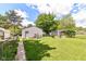 Large backyard with lush grass, a detached garage, and a fence for privacy, perfect for outdoor activities at 518 N Emerson Ave, Indianapolis, IN 46219