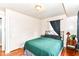 Cozy bedroom with hardwood floors, neutral walls, and a comfortable bed beneath a window at 518 N Emerson Ave, Indianapolis, IN 46219