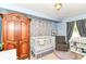Charming bedroom features a crib, dresser, and cozy chair, creating a warm, inviting space at 518 N Emerson Ave, Indianapolis, IN 46219