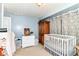This Bedroom features light blue walls, white furniture, and soft curtains that add a peaceful and calming ambiance at 518 N Emerson Ave, Indianapolis, IN 46219