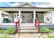 Inviting front porch with classic columns, seating, and beautiful greenery, offering a welcoming curb appeal at 518 N Emerson Ave, Indianapolis, IN 46219