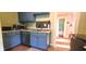 Charming kitchen features blue cabinets, stainless steel appliances, and hardwood floors at 518 N Emerson Ave, Indianapolis, IN 46219