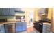 Bright kitchen features blue cabinets, stainless steel appliances, and hardwood floors at 518 N Emerson Ave, Indianapolis, IN 46219