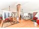 Spacious living area featuring hardwood floors, an exposed brick pillar, and an open layout perfect for entertaining at 518 N Emerson Ave, Indianapolis, IN 46219