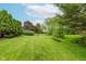 A well-manicured backyard with green grass and mature trees at 5251 Apache Moon, Carmel, IN 46033