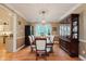 Charming dining room featuring a wooden table with seating for six, a china cabinet and a modern light fixture at 5251 Apache Moon, Carmel, IN 46033