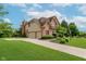 Spacious home with three-car garage, brick accents, mature trees, and a long driveway at 5251 Apache Moon, Carmel, IN 46033