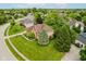An aerial view shows a two-story brick home with a well manicured lawn and mature landscaping at 5251 Apache Moon, Carmel, IN 46033