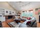 Comfortable living room includes a fireplace, custom built-ins, a ceiling fan and a large window at 5251 Apache Moon, Carmel, IN 46033