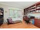 Home office offers built-in bookshelves, hardwood floors, and a large window overlooking the front yard at 5251 Apache Moon, Carmel, IN 46033