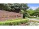 A brick sign marks the entrance to Delaware Trace, complemented by flowering plants and manicured shrubs at 5251 Apache Moon, Carmel, IN 46033