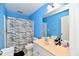 Bathroom with white single sink vanity, shower with curtain, toilet, and blue walls at 5758 N 900 W, Thorntown, IN 46071
