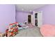 Bright bedroom featuring purple walls, a play pizza truck, closet, and plush carpet for comfort at 5758 N 900 W, Thorntown, IN 46071