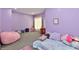 Cozy bedroom with vibrant purple walls, beanbag chair, and plush carpet, perfect for relaxation and play at 5758 N 900 W, Thorntown, IN 46071