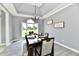 Formal dining room with a tray ceiling, gray walls, modern chandelier, and large window at 5758 N 900 W, Thorntown, IN 46071