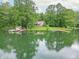 Overhead view of a lakeside home with private docks, surrounded by lush greenery and still water at 5821 Bittersweet Rd, Morgantown, IN 46160