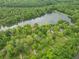 Breathtaking aerial view of a lake surrounded by dense woods and a small cluster of homes nestled in the trees at 5821 Bittersweet Rd, Morgantown, IN 46160