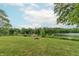Picturesque backyard with a lush lawn, leading to a serene lake and a private wooden dock at 5821 Bittersweet Rd, Morgantown, IN 46160