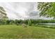 Picturesque backyard with a lush lawn, leading to a serene lake and a private wooden dock at 5821 Bittersweet Rd, Morgantown, IN 46160