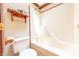 A bathroom with toilet, bathtub, and a shelf with decorations hanging on the wall at 5821 Bittersweet Rd, Morgantown, IN 46160