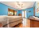 Bright bedroom featuring light blue walls, wood floors, and a walk-through to a workout space at 5821 Bittersweet Rd, Morgantown, IN 46160