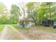 Charming detached garage with an American flag, a porch swing, and a gravel driveway surrounded by trees at 5821 Bittersweet Rd, Morgantown, IN 46160