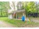Charming detached garage with an American flag and a porch swing surrounded by lush trees and greenery at 5821 Bittersweet Rd, Morgantown, IN 46160