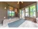 Relaxing sunroom with brick floor and steps, ceiling fan, and views of the outdoors at 5821 Bittersweet Rd, Morgantown, IN 46160