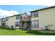 View of the back of the townhome featuring a deck, balcony, and large windows overlooking the grassy lawn at 608 Cielo Vista Dr, Greenwood, IN 46143