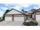 Charming townhome featuring attached two-car garage and a welcoming front entrance with landscaped flower beds at 608 Cielo Vista Dr, Greenwood, IN 46143