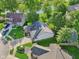 Aerial view of home, surrounded by manicured lawns and mature trees, near a pond at 7061 Woodgate Cir, Fishers, IN 46038