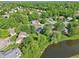 Expansive aerial view of a residential neighborhood featuring lush greenery and a tranquil pond at 7061 Woodgate Cir, Fishers, IN 46038