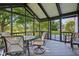 Screened in back porch with a glass table and chairs, overlooks a grassy lawn and pond at 7061 Woodgate Cir, Fishers, IN 46038