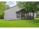 Inviting back porch with covered seating area and adjacent deck surrounded by lush green lawn at 7061 Woodgate Cir, Fishers, IN 46038