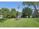 This home's backyard includes an American flag, mature trees, landscaping, and a screened in porch at 7061 Woodgate Cir, Fishers, IN 46038