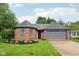 Charming brick home featuring an attached garage and a well-manicured lawn, with a red front door at 7061 Woodgate Cir, Fishers, IN 46038