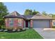 Charming brick home featuring an attached garage and a well-manicured lawn, with a red front door at 7061 Woodgate Cir, Fishers, IN 46038