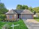 Charming home with brick accents, manicured landscaping, and a gray two-car garage at 7061 Woodgate Cir, Fishers, IN 46038