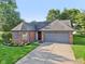 Aerial view of a charming home with a brick facade, well-maintained landscaping, and a two-car garage at 7061 Woodgate Cir, Fishers, IN 46038