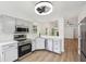 Updated kitchen features stainless appliances, gray cabinets, new countertops, and a modern lighting fixture at 7061 Woodgate Cir, Fishers, IN 46038